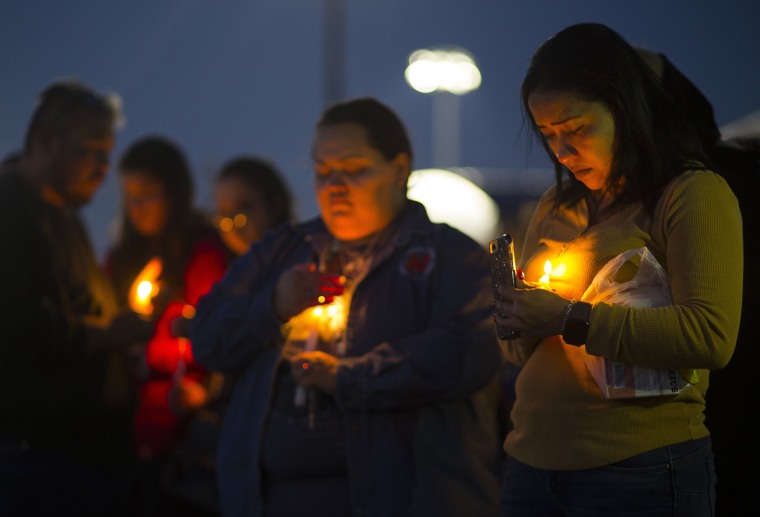 Image: Ericka Rivera, right, attends a prayer vigil