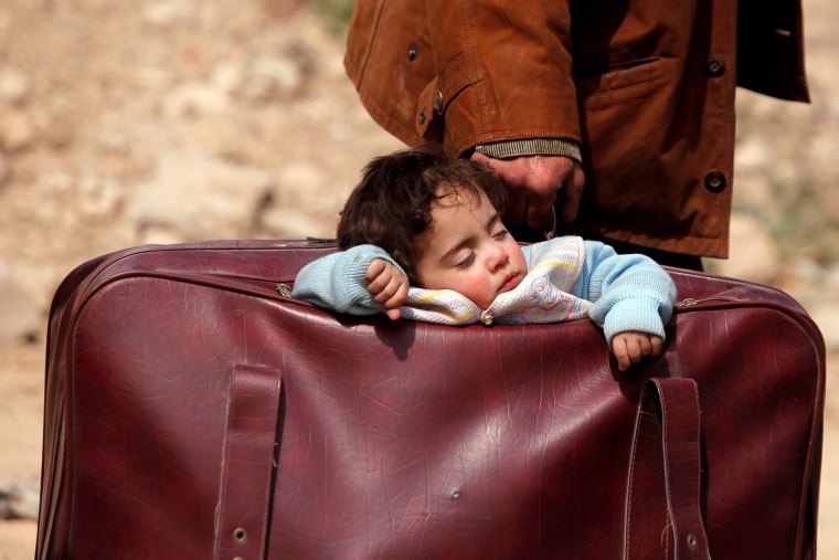 Image: A child sleeps in a bag in the village of Beit Sawa