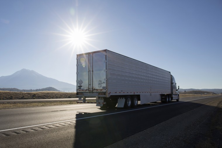 Semi-trailer truck motors along empty highway