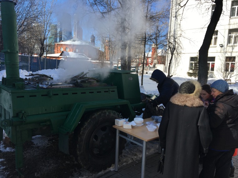 Russian voters enjoy a quick meal of buckwheat outside a polling station on Kutuzovsky Avenue in central Moscow on March 18, 2018.