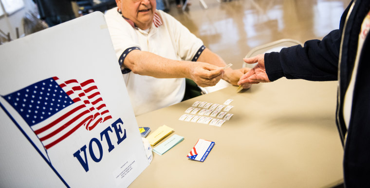 A poll worker hands out stickers to voters at a polling station on April 26, 2016 in Hanover, Pennsylvania.