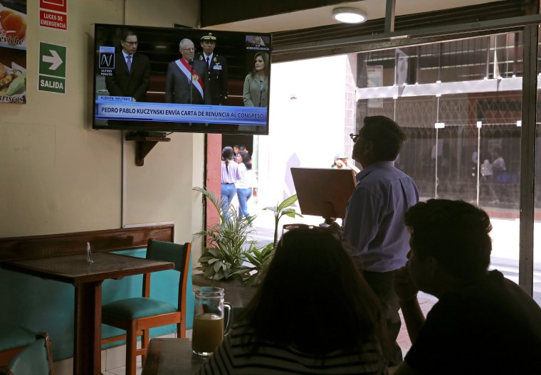 Image: People look on as Peru's President Pedro Pablo Kuczynski addresses to the nation as he resigns in Lima