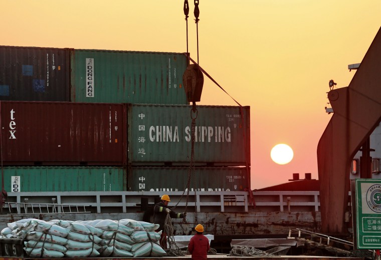 Image: Workers load ships at a port in Nantong in China's eastern Jiangsu province