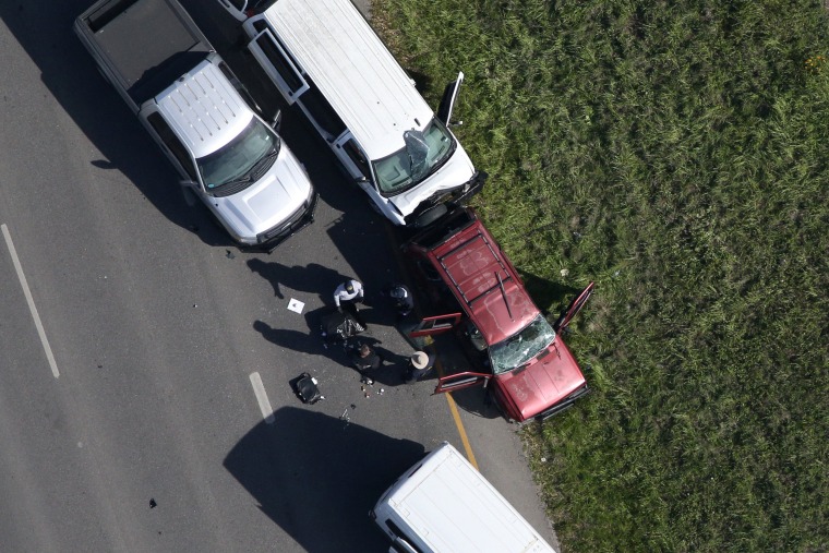 Image: Law enforcement personnel investigate the scene where the Texas bombing suspect blew himself up on the side of a highway north of Austin in Round Rock