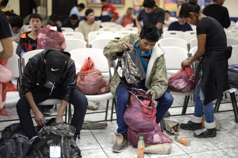 Image: A group of deported immigrants gather their belongings