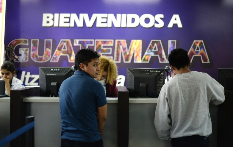 Image: Deported immigrants wait to be registered