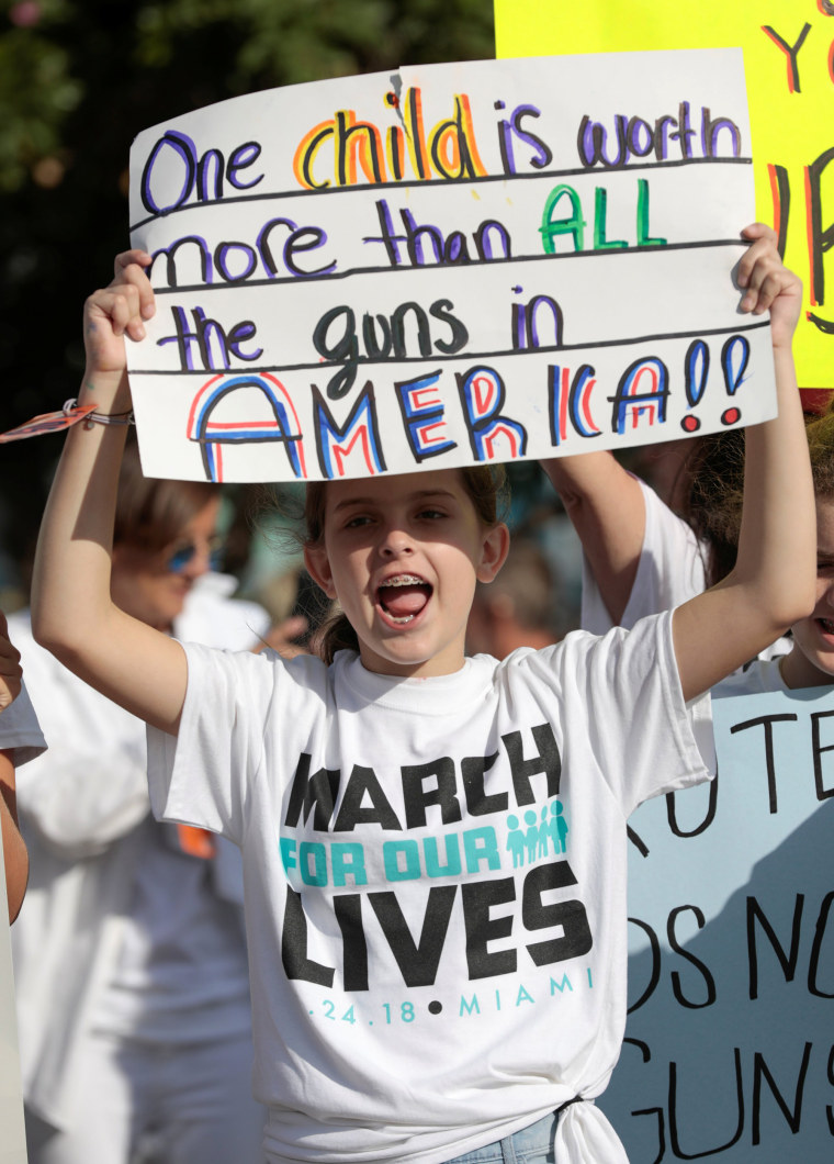 A girl holds a sign while rallying in the street in Miami, Florida.