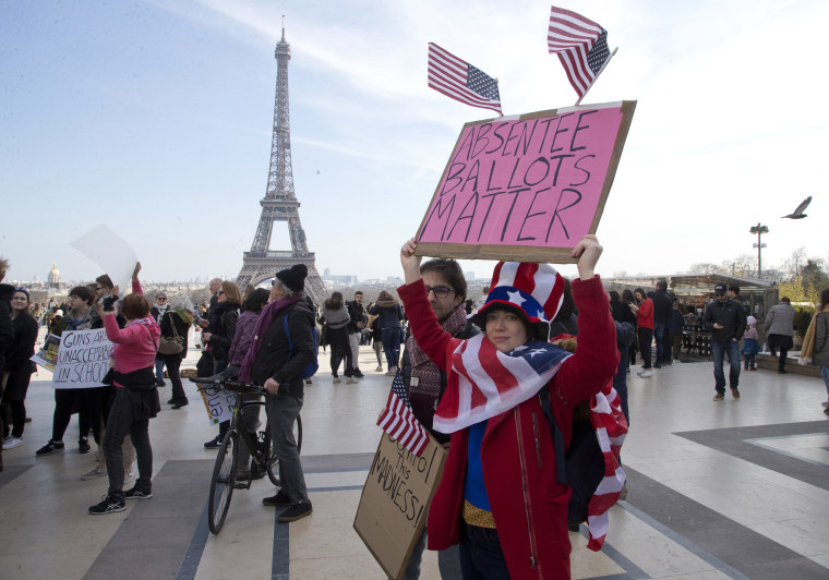 People hold banners in a march to support the demonstrators in the U.S., in Paris, France.