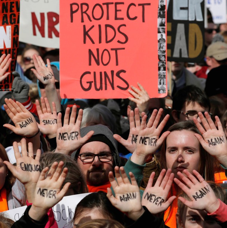 March participants carry signs and display the slogans on their hands as students and gun control advocates take to the streets in Washington, DC.