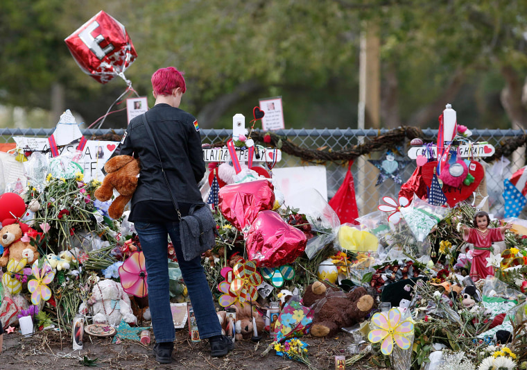 Image: A Marjory Stoneman Douglas High School student stops to look at one of the memorials