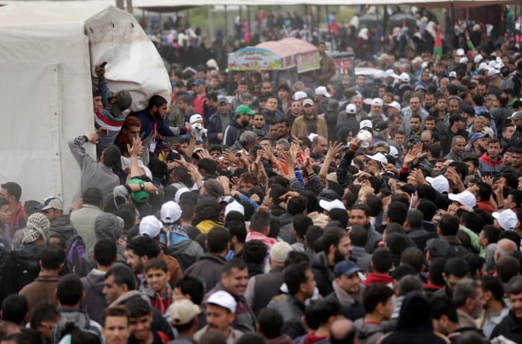 Image: Palestinians gather to receive lunch packages during a protest