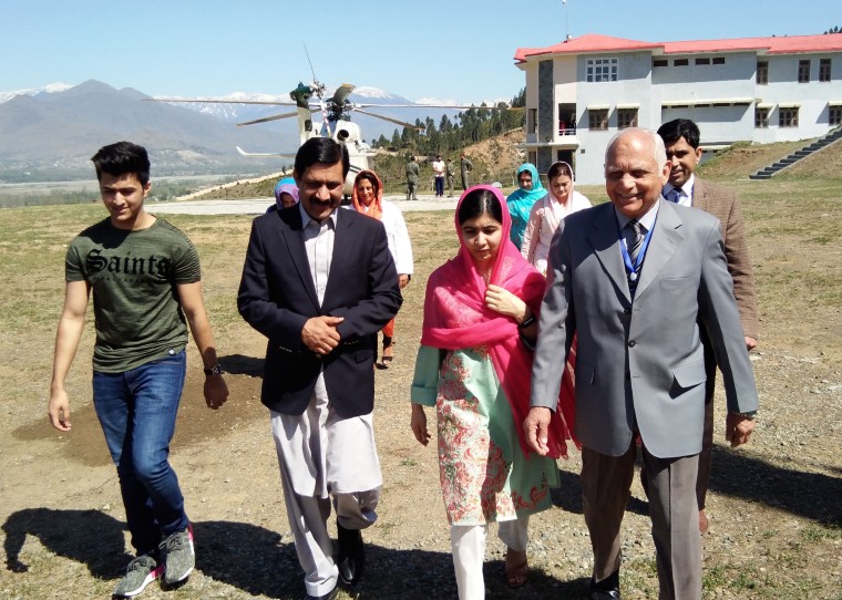 Image: Malala Yousafzai walks with her father, Ziauddin (2L), brother Atal (L) and Guli Bagh, the principal of the all-boys Swat Cadet College.
