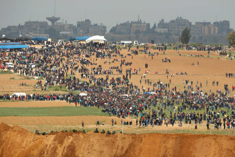 Image: Palestinians participate in a tent city protest commemorating Land Day, with Israeli soldiers seen below in the foreground, March 30, 2018.