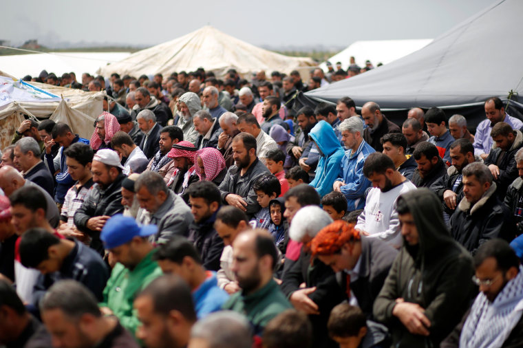 Image: Palestinians pray on the Gaza border with Israel, east of Jabalia, on March 30, 2018, during mass protests along the border of the Palestinian enclave, dubbed "The Great March of Return," which has the backing of Hamas.