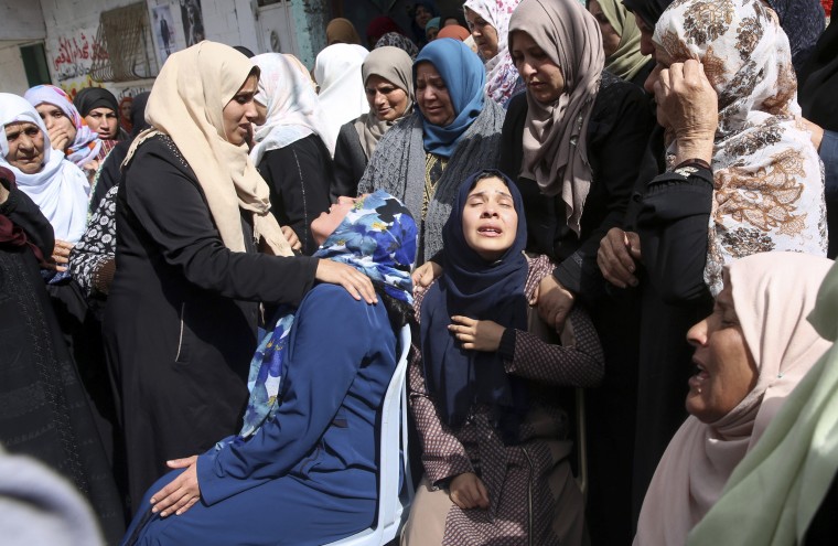 Image: Relatives mourn as the crowd carries the body of Hamdan Abu Amsha, 23, during his funeral in front of his family house in Beit Hanoun, Gaza Strip, on March 31, 2018.