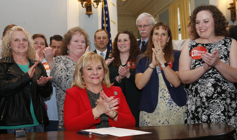 Image: Surrounded by teachers and legislators, Oklahoma Gov. Mary Fallin applauds after signing a teacher pay raise bill in Oklahoma City