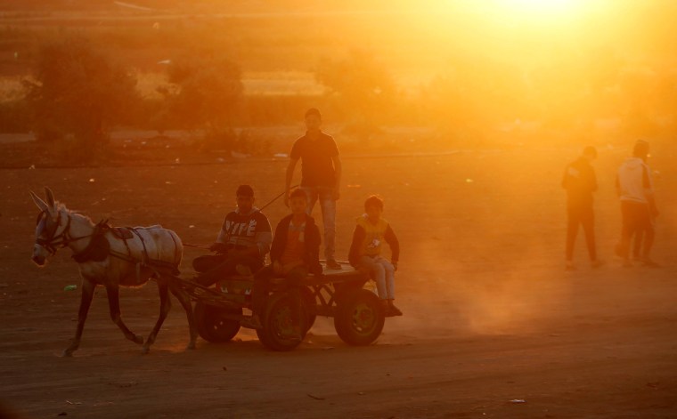 Palestinians ride a donkey as they pass by the Israel-Gaza border, east of Gaza City on April 1.