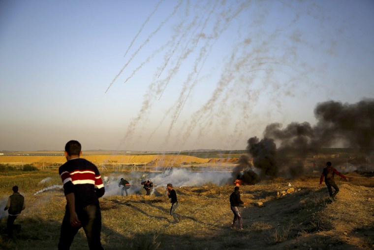 Palestinian protesters run from tear gas fired by Israeli forces on April 1.
