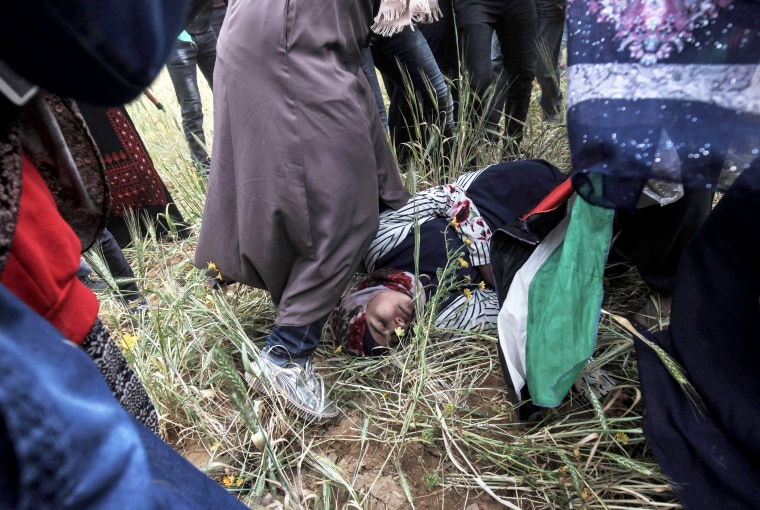 An injured Palestinian woman lies on the ground on March 30.