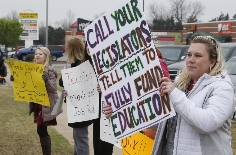 Image: Teacher Adrien Gates pickets with other educators on a street corner in Norman, Oklahoma