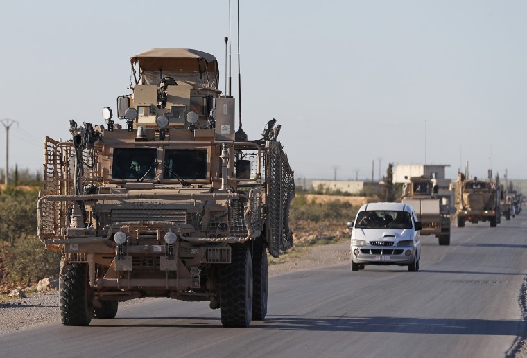 A convoy of U.S. troops drive on a road leading to the tense front line with Turkish-backed fighters in Manbij, north Syria, on Saturday.