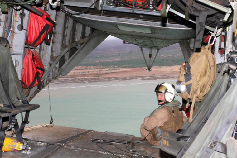 Image: A Marine assigned to Marine Medium Tiltrotor Squadron (VMM) 166, mans the rear cargo hatch during a flight over Camp Lemonnier and surrounding area