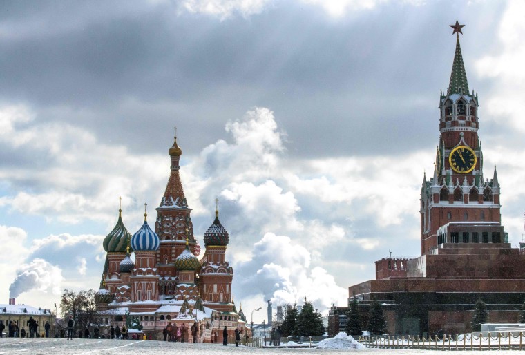 Image: People walk in front of St. Basil's Cathedral and the Kremlin on Red Square