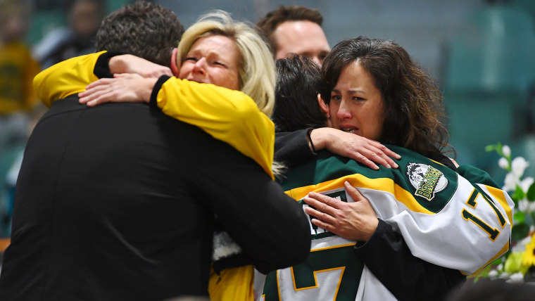 Image: Mourners comfort each other at a vigil to honor Humboldt Broncos members who died in fatal bus accident. 