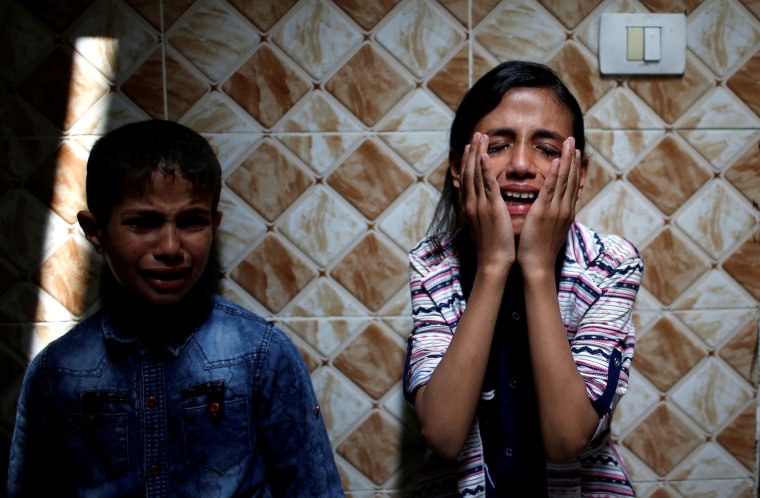 Image: Palestinian relatives of Hamas gunman Mohammed Hejelah, who was killed in an Israeli air strike, mourn during his funeral in Gaza City