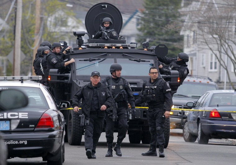 Image: SWAT teams enter a suburban neighborhood to search an apartment for the remaining suspect in the Boston Marathon bombings in Watertown