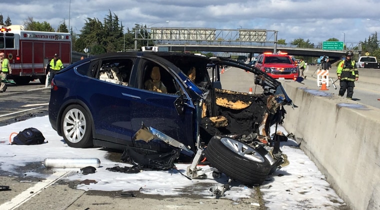 Image: Rescue workers attend the scene where a Tesla electric SUV crashed into a barrier on U.S. Highway 101 in Mountain View