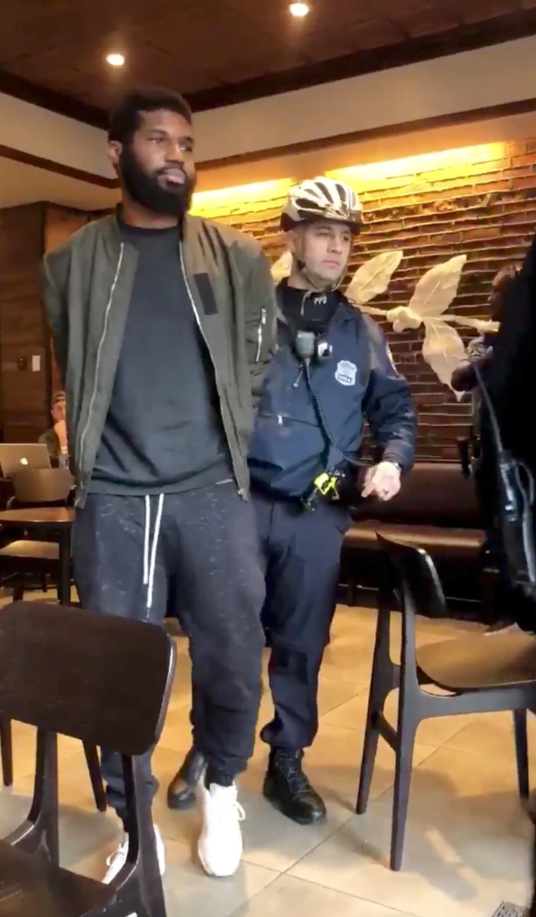 Image: Police officers detain a man inside a Starbucks cafe in Philadelphia
