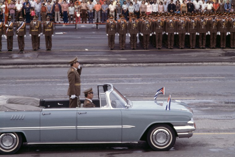 Raul Castro waves from a car while riding through Havana, in a military parade, May 1978.