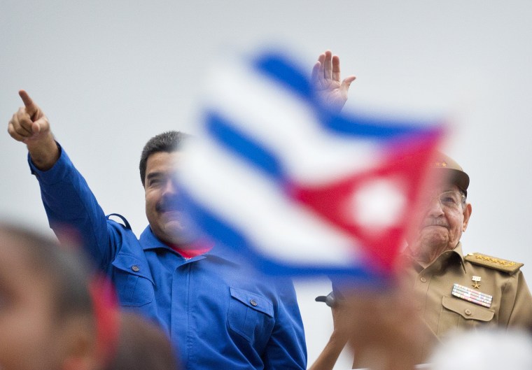 Venezuela's President Nicolas Maduro and Raul Castro, acknowledge marchers as they parade past, marking May Day in Revolution Square, in Havana, May 1, 2015.