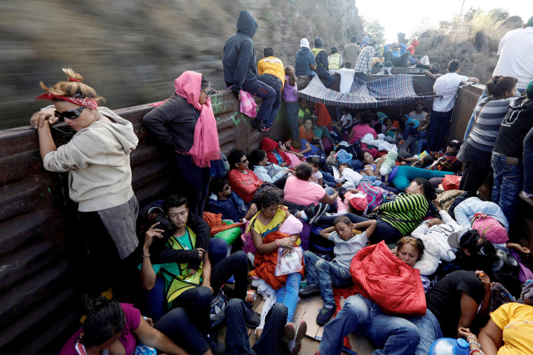 Image: Central American migrants, moving in a caravan through Mexico, journey an open wagon of a freight train after stopping it on the rail line, in Hidalgo state