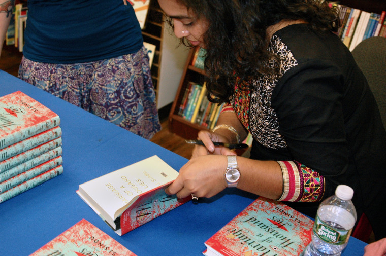 Image: SJ Sindu signs copies of her novel, "Marriage of a Thousand Lies."