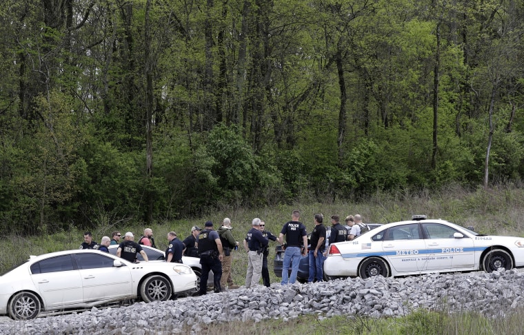 Image: Police gather on a road along a wooded area where Waffle House shooting suspect Travis Reinking was captured