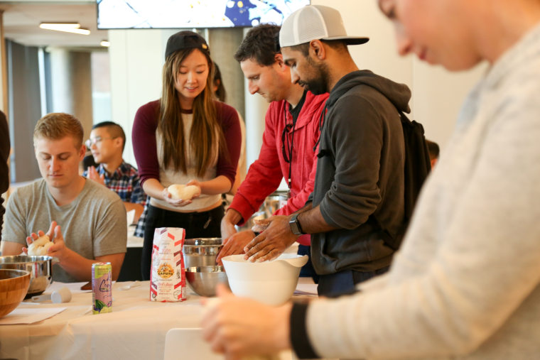 Pinterest engineer Kathy Zhou leads colleagues in mixing, kneading, and even tossing pizza dough in her "On the rise" course at Knit Con.