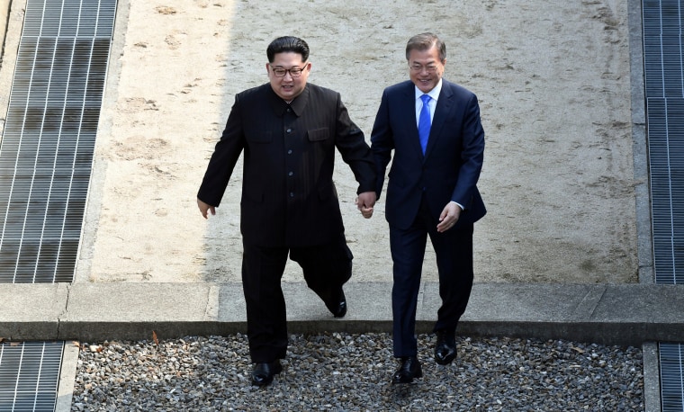 Image: Kim Jong Un and Moon Jae-in cross the military demarcation line at Panmunjom, Friday.