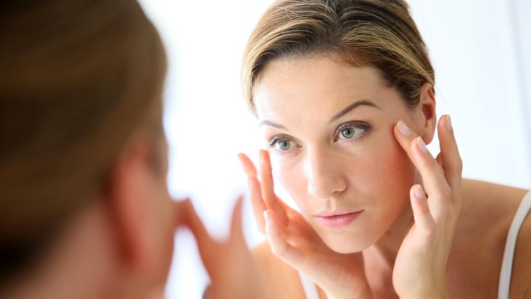 woman in her 40s applying wrinkle cream