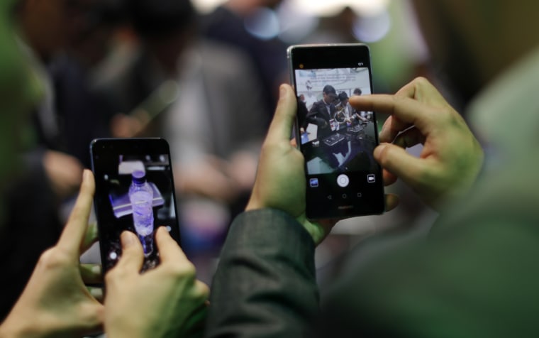 Image: Visitors try Huawei's devices during Mobile World Congress in Barcelona