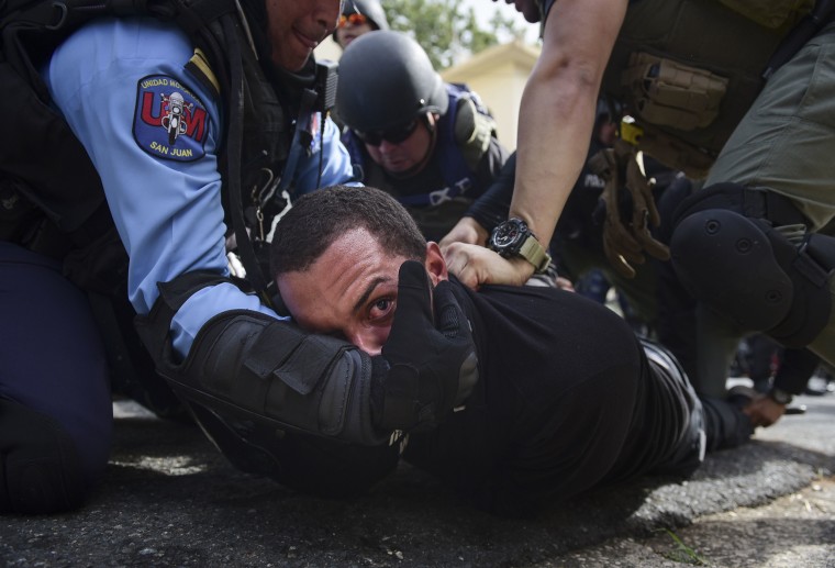 Image: Police detain a protester after a May Day march turned violent in San Juan