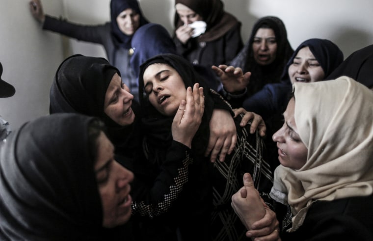 Image: Mourners console the mother of 15-year-old Palestinian teenager