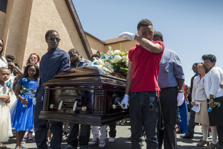 Image: A pallbearer wipes a tear at the end of the funeral for Diante \"Butchie\" Yarber