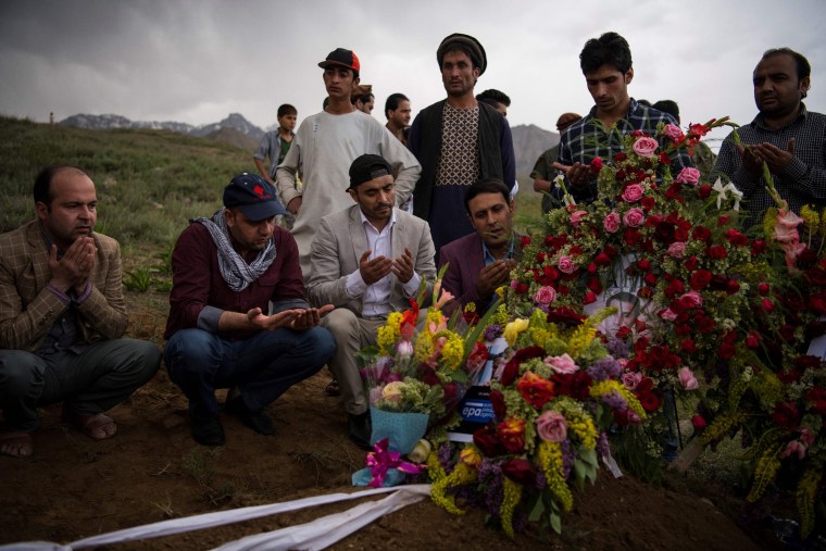 Image: Friends and relatives of Agence France Presse chief photographer Shah Marai Faizi gather at his burial