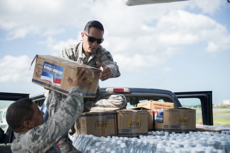 Senior Master Sgt. Jan Paravisini, a maintenance management analyst with the 156th Airlift Wing, loads supplies onto a truck, Nov. 22, 2017, in Isla Grande Airport, Puerto Rico.