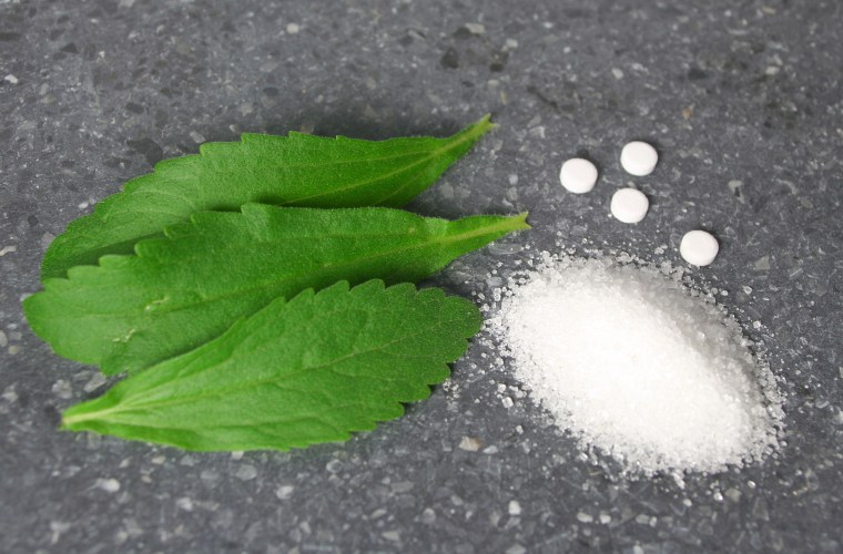 Stevia leaves with pile of sugar