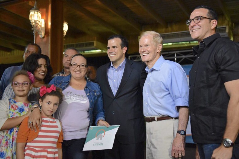 Gov. Ricardo Rossello of Puerto Rico, center, and Sen. Bill Nelson, D-Fla., grant property titles on the island.