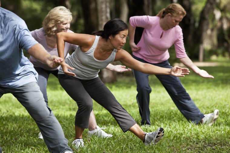 Image: People practice tai chi in park.