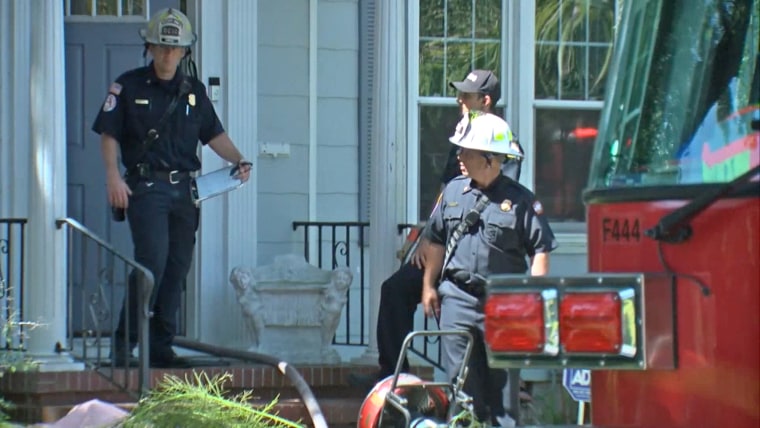 Image: Fire rescue workers stand outside the house of a man who died after a vape pen exploded